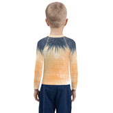 Child wearing Pirate Treasure Hunt Rash Guard by the beach.